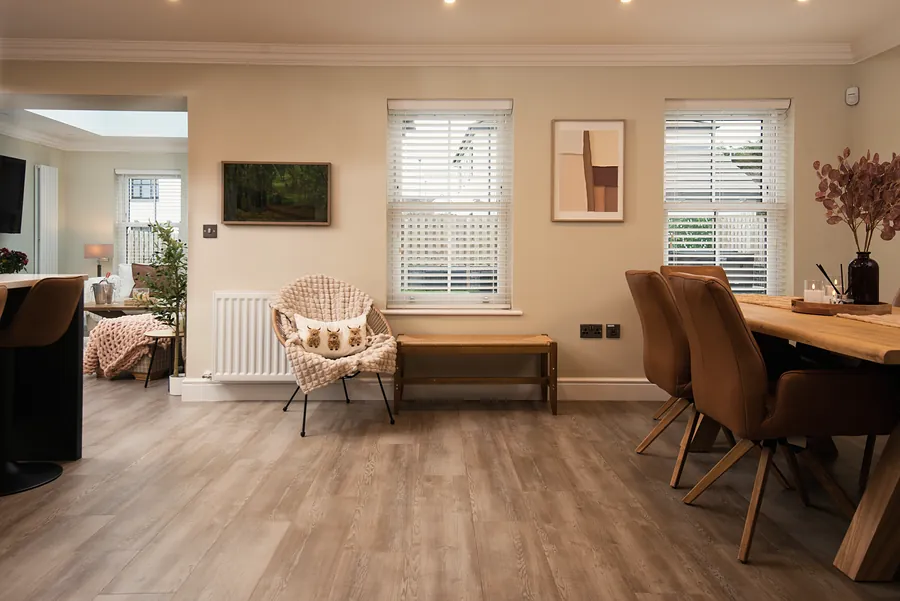 Oak dining table with leather chairs by the window