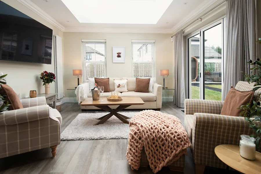 Second lounge with armchairs and a pink knitted throw