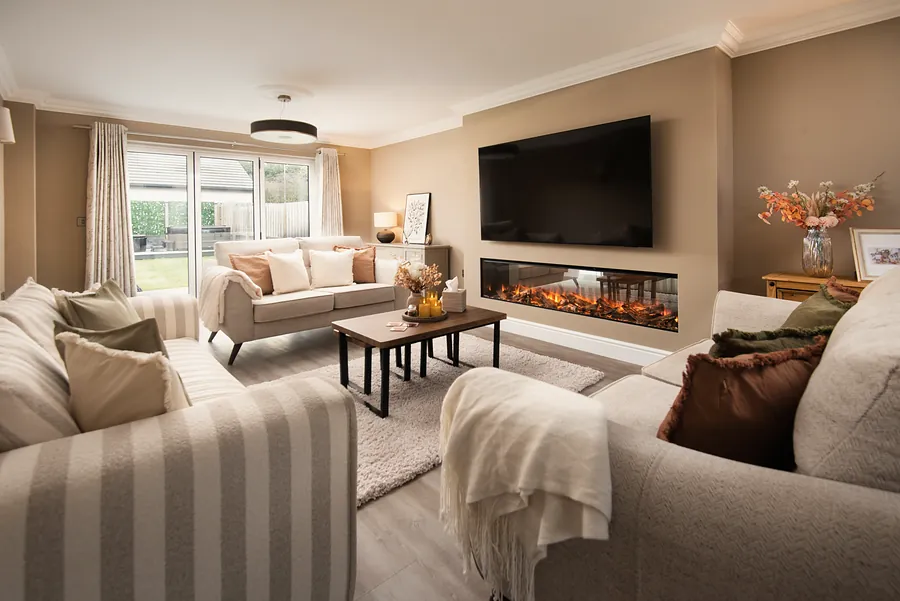 Lounge with sofas, throws and a wide fire beneath the TV